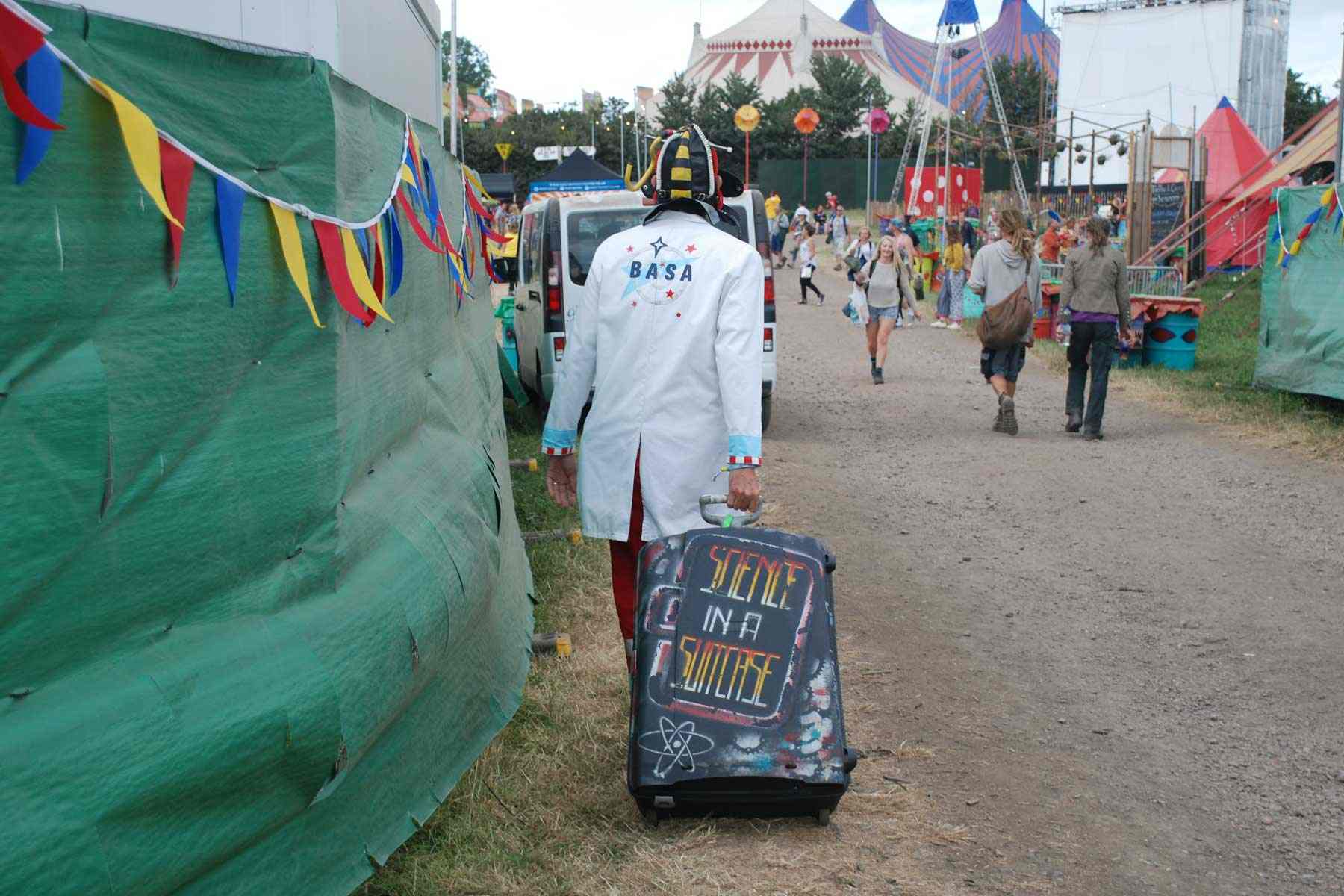 Glastonbury festival - Science in Suitcase Show Dr Ken is outstanding in a field dressed in his BASA outfit with a suitcase spray painted with the words "Science in a Suitcase".