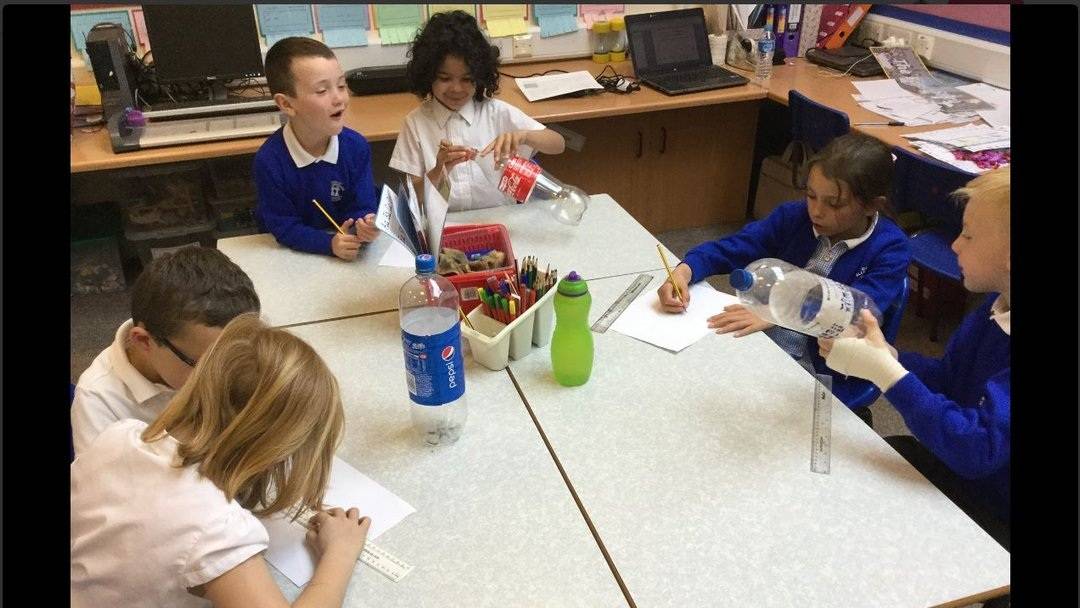 Environmental science recycling investigation school workshop Small groups of School pupils discuss their designs for a wind turbine recycling activity.