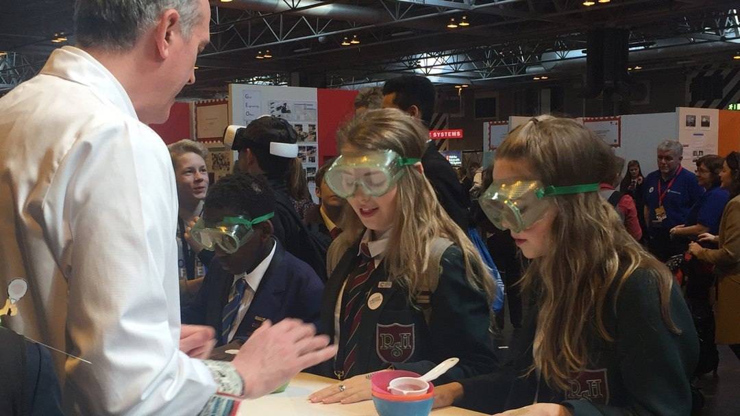 Hands on Seperation experiments at the BIG BANG FAIR for URENCO Three goggle wearing high school pupils get ready to race one another to separate a mixture of 3 different solids into 3 different plastic bowls using only a sieve and their hands.