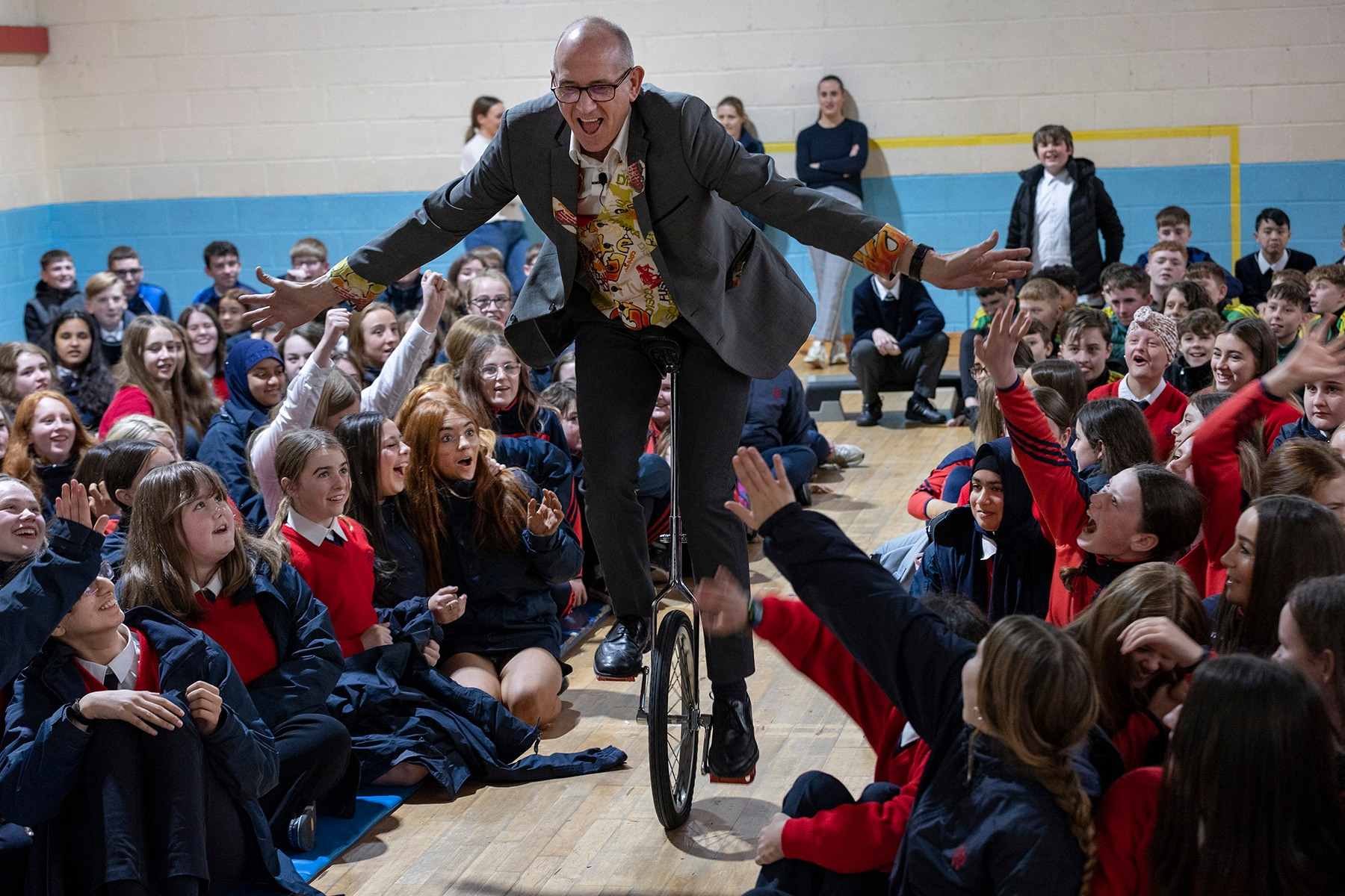 Dr Ken riding a Unicycle and interacting with the audience in Ireland Excited audience members interact with Dr Ken as he unicycles through the middle of them.